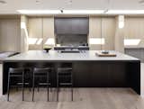 Streamlined kitchen cabinetry is accented by Gaggenau appliances and Basaltina stone countertops.