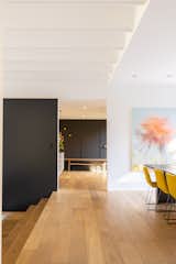 The wood flooring and white walls contrast with a black wall, creating an eye-catching effect.