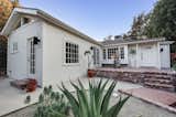 Recently listed in the Glassell Park neighborhood of Los Angeles, this renovated and expanded 1940s cottage sits on an elevated lot above other homes on the street. Multiple patios surround the L-shaped structure, providing a welcoming entrance.  Photo 1 of 16 in Listed at $950K, This Clean-Lined Cottage in Los Angeles Is a Fresh Take on City Living