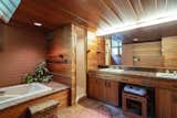 The adjacent bathroom continues the material palette of flagstone, mahogany, and brick.