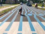 Steven Lewis poses by colorful markings on a street in Detroit, designed to slow down drivers, and make them conscious of their surroundings.