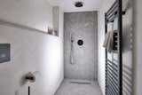 The en suite shower room offers tile by&nbsp;Bert &amp; May alongside Vola fixtures.