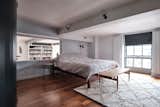 Bedroom, Bed, Wall Lighting, Dark Hardwood Floor, Bench, and Night Stands Upstairs, a movable wall partition opens the principal suite to the living area below.  Photo 9 of 13 in For £1.2M, Snag This Spacious London Flat Inside a Converted Victorian Schoolhouse
