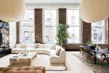 The renovation embraced century-old features including a row of six massive windows that illuminate the entire space. Other original details include 16-foot ceilings, exposed brick walls, and Corinthian columns.