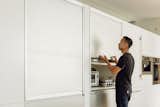 Kitchen appliances are hidden behind sliding aluminum "garage" doors.