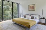 In the couple’s bedroom, a Nook upholstered platform bed from Blu Dot is flanked by C Shape end tables from Yamazaki Home.