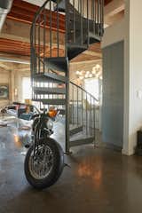 An industrial staircase spirals up to the second floor, where an office/guest room and half-bath can be found.&nbsp;
