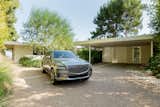 The Genesis GV80 sits near the open carport of the Clear Oak Residence.