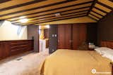The primary bedroom continues the interior aesthetic with wood-clad walls and ceilings.