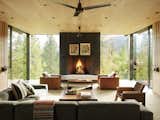 Living Room, Standard Layout Fireplace, Recessed Lighting, Sectional, Light Hardwood Floor, Rug Floor, Coffee Tables, Chair, and Wood Burning Fireplace  Photos from A Kinetic Facade Opens This Spectacular Mountain House to the Grand Teton Landscape