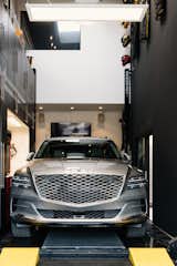 A Genesis GV80 sits on a BendPak High Bay Lift on the ground floor of the garage.