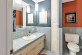Two full bathrooms are also located on the main level. Here, one of the bathrooms features original cabinetry and colorful tiles.