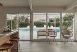 A wall of windows and a sliding glass door provide views of the backyard pool.