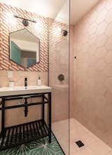 Designer tile work covers the walls and floor in the bathroom, enhancing the modern decor.