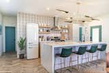 Graphic wallpaper punches up the kitchen, where pink tiles form the backsplash and kitchen island.