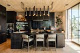 Kitchen, Marble Counter, Range, Ceramic Tile Backsplashe, Light Hardwood Floor, Wall Oven, Wood Cabinet, Range Hood, and Pendant Lighting  Photo 1 of 7 in An Architect’s Dream Kitchen Channels SoCal’s Laid-Back Vibes With a Fusion of Homey Materials