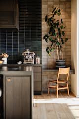 Flanking both sides of the backsplash are grey Heath tiles that were installed backwards to reveal the unglazed side. Leathered granite countertops add yet another contrasting texture within the space.