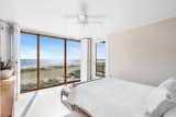 Upstairs, the single bedroom features full-height windows overlooking the beachfront and Atlantic Ocean. A side door leads to the rooftop deck.&nbsp;