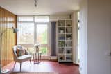 The ground level also includes a flexible space that can serve as a reading nook or an additional dining area. Original deep-red linoleum flooring pops against the white walls.   Photo 7 of 12 in A British Architect’s Picturesque Prefab Seeks £1.2M