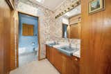 The principal bathroom offers original cabinetry and wood paneling, along with a separate toilet and shower closet.  Photo 11 of 15 in Moritz Kundig’s Historic Wallmark House Offers Lakefront Living for $1.1M