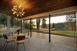 Outside, a covered dining area overlooks the wooded landscape. A deck along the edge of the property provides sweeping views of Long Lake below.
