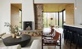 In the double-height living area, a pair of vintage Sirocco chairs by Arne Norell face an oval coffee table from Elte.