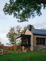 A new cedar and glass dining pavilion extends through the back of a weekend retreat in rural Ontario designed by architect Brian O'Brian for Ben Sykes and Erin Connor. The 19th-century timber and stone structure, formerly a one-room schoolhouse, proved to be the perfect palimpsest for a modern intervention.