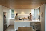 Kitchen, Refrigerator, and White Cabinet In the kitchen and dining area, chairs from Nood slide under the island and surround a Maraetai table from The Axe.  Photo 3 of 17 in A Musician Couple’s Wedge-Shaped House Echoes the Majesty of the New Zealand Landscape