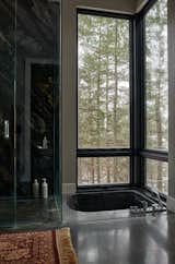 The en suite bathroom is clad in Brazilian marble and features a pair of Ultimate Awning and Picture windows surrounding the sunken tub. "I see the glass as more than just a transparent barrier to the outside," Peck comments. "The Marvin windows take a back seat—so much that you don’t even notice them."