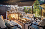 Dating to the early 1900s, a stone fireplace provides a focal point for the covered seating area.  Photo 12 of 14 in Case Study Architect Whitney R. Smith’s SoCal Residence Lists for $2.35M