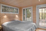 The bedroom showcases the cross-laminated timber logs used by Pluspuu, which have mitered edges for a softer look. The home—like all of Pluspuu’s models—features triple-glazed windows that provide insulation in a wide variety of climates.