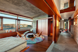 The principal suite features&nbsp;bush-hammered concrete walls, expansive windows, and built-ins.