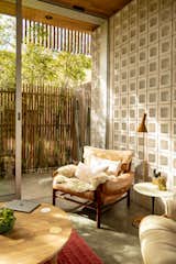 Concrete floors, a cinder block wall, wooden furniture, and views of the bamboo garden come together to create a design that’s grounded in natural elements.