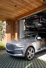 The Genesis GV80 is parked in on the lower level of the vertical garage at the Walk-Street House. A Genesis G80 sits on the lift.

Preproduction model with optional features shown.

