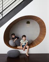 An area underneath a cellar staircase becomes an egg-shaped play area in Tang’s hands. The white oak–lined nook features Abigail Edwards wallpaper with a subtle wave pattern.  Photo 5 of 13 in How to Design a Room That Grows Up With Your Kids
