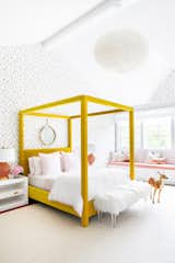 At the Silo Ridge Farmhouse by Chango &amp; Co., a cheery yellow canopy bed by Jayson Home and dotted wallpaper from Brewster Home create a vibrant girl’s bedroom.