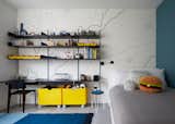 The parents of a five-year-old boy feared that his room would read “too young” when he grew up, so Tang infused the space with elements that would balance fun and flexibility. A graphic topological map from HappyWall and yellow color blocking add youthfulness while Vitsoe modular shelving and custom bins on casters ensure that the room can be adjusted.  Photo 3 of 12 in New Home by Paul Ninson from How to Design a Room That Grows Up With Your Kids