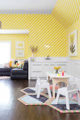 A playroom in Rumson, New Jersey, designed by Chango &amp; Co. features a kitchenette and bold, striped yellow wallpaper. The table and chairs are from Land of Nod, and underfoot is a rug from Kinder MODERN.  Photo 9 of 13 in How to Design a Room That Grows Up With Your Kids