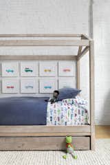 Chango &amp; Co. renovated a young family’s loft in Dumbo, Brooklyn, adding a canopy bed from&nbsp;RH Baby &amp; Child&nbsp;and bedding from Pottery Barn Kids in the boy’s bedroom. Car artwork from Leslee Mitchell carries out the transportation theme.