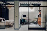 Steel-and-glass walls enclose two other rooms, now set up as a guest room and office.