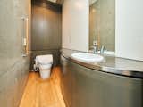 Finishes in each bathroom carry forward the exposed concrete and stainless steel found in other rooms of the apartments.