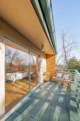 The sliding doors open onto a private balcony overlooking the treetops.