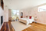 Patterned, blush-pink wallpaper adds a hint of color in one of the home’s five bedrooms.