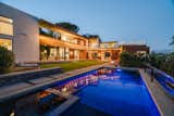 A view from across the pool highlights the sprawling, manicured backyard.