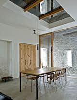 In the dining area, the barn’s structure is visible through both a skylight and a glass wall with a sliding door.