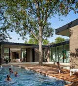 Though parties might be on hold for a bit longer, this midcentury-style, brick-and-glass house in Austin, Texas, stands ready to entertain. Its owners, Sherry and Anthony, credit their architect and close friend, Eric Hughes of Houston firm HR Design Dept, for accommodating their penchant for Southern hospitality. For example, visitors can come right into the kitchen—the formal entrance off the front walkway gets much less use than the door from the carport—and be promptly handed a drink across the generous island. "There’s an overarching communal flow to the home and the way in which entertaining spaces work together, and then there are these separate, choreographed moments within that," says Hughes.