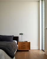 The couple’s bedroom features a Nook bed from Blu Dot, a vintage bedside table, and linens from Parachute.