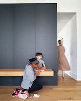 Zuri gives Mateo a hand in front of the floating white oak bench in the entryway.