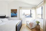 Bedroom, Chair, Light Hardwood Floor, and Bed The second floor of the back house includes a guest suite and an office. The walls are painted in Benjamin Moore’s Chantilly Lace.  Photos from A Svelte ADU Gives a Los Angeles Bungalow Room to Breathe