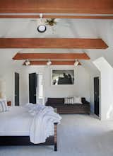 Wooden beams span the ceiling in the upper-level bedroom of the guesthouse, which comes with a remodeled bath.